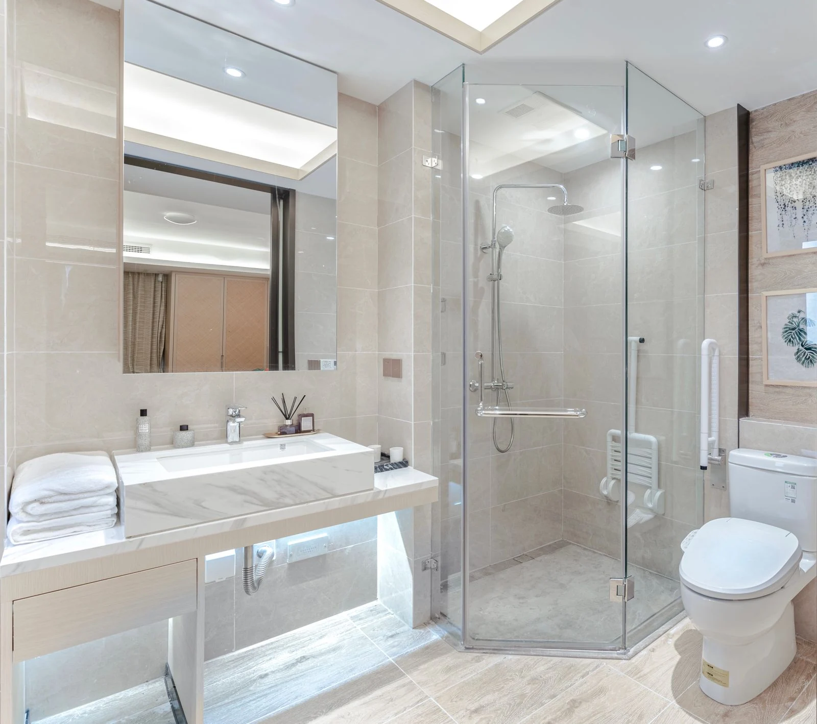 A stylish bathroom featuring a glass shower, marble sink, and elegant decor