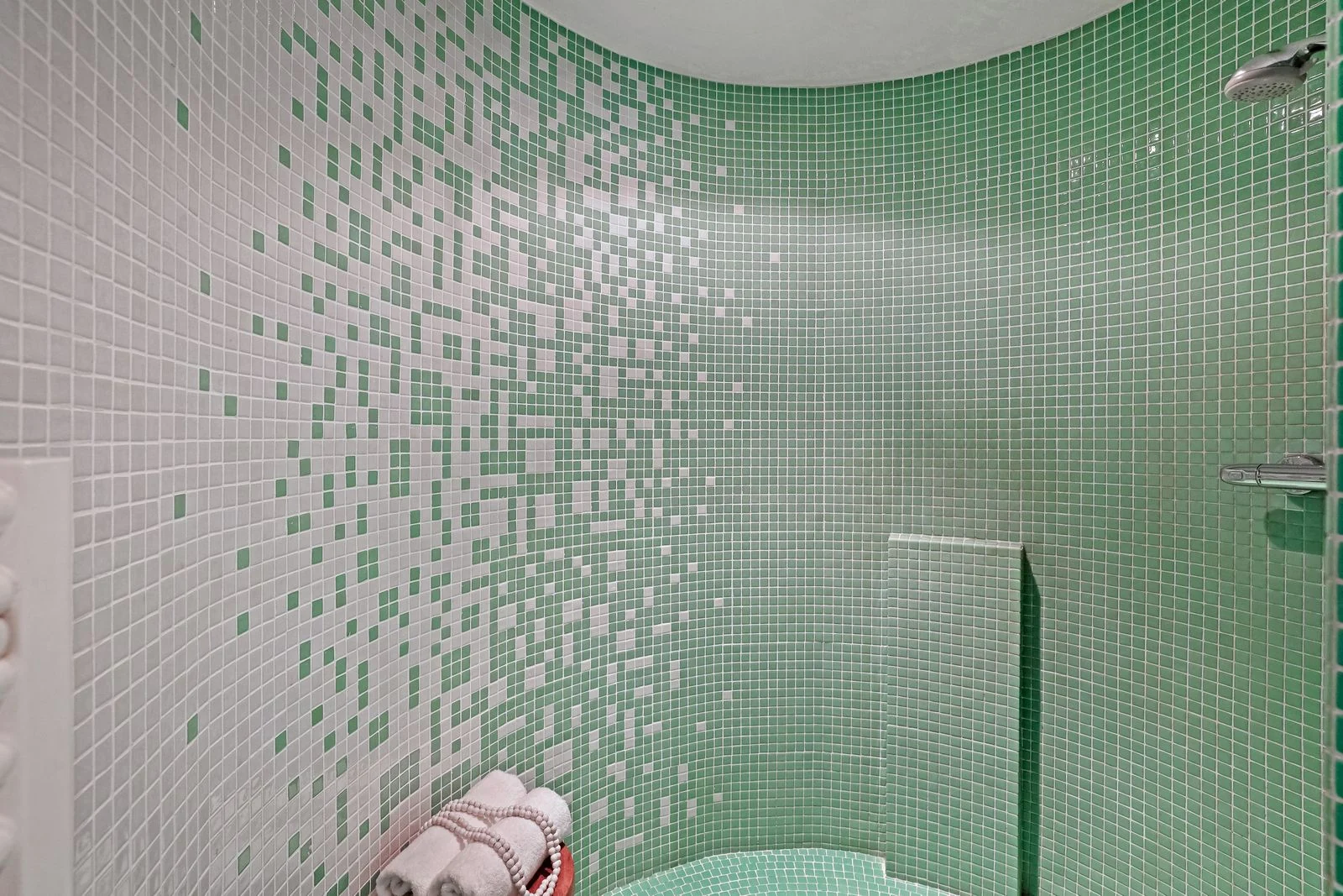 Green mosaic tiles around a shower