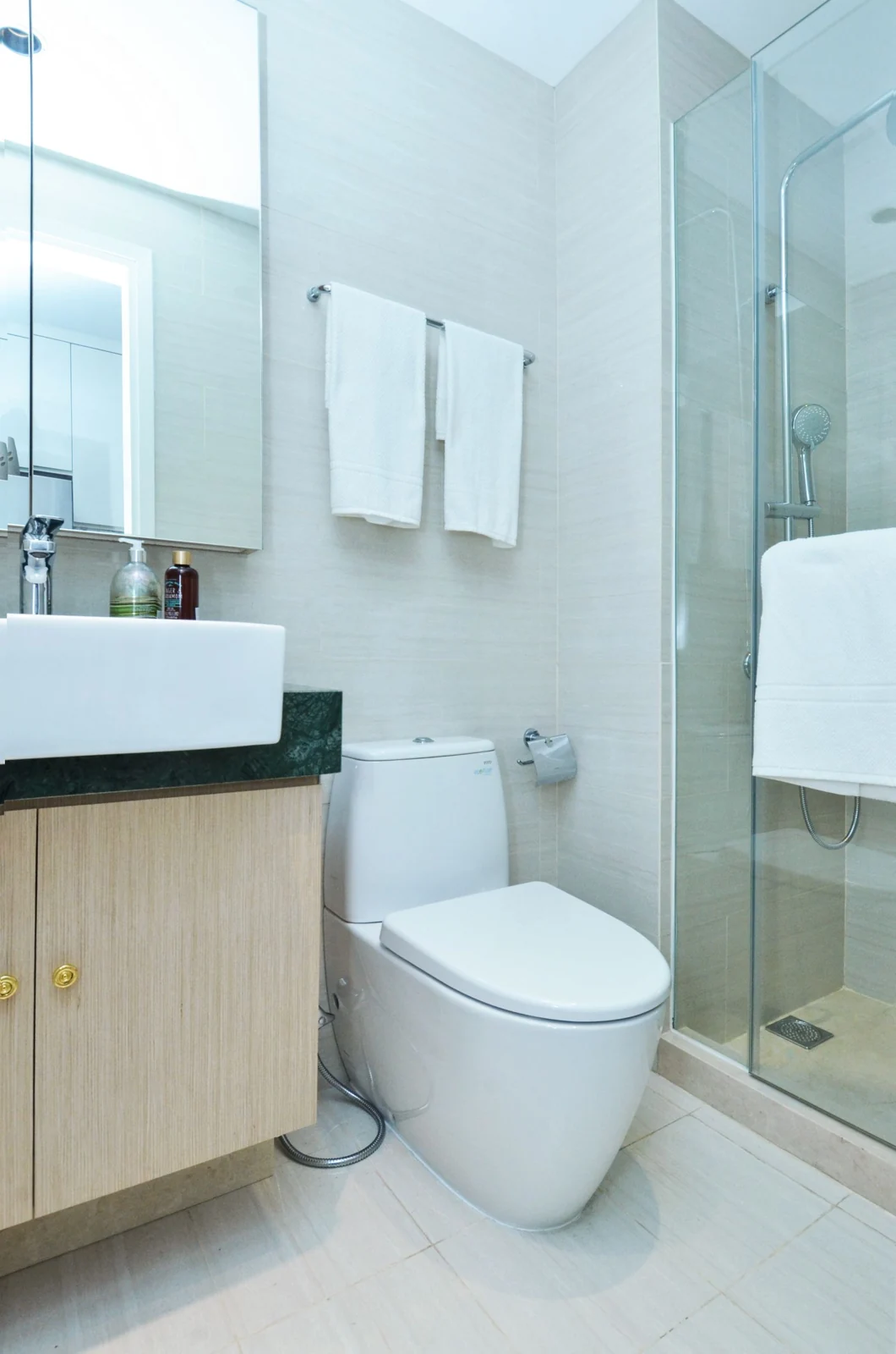 A sleek and clean modern bathroom featuring a shower, toilet, and sink