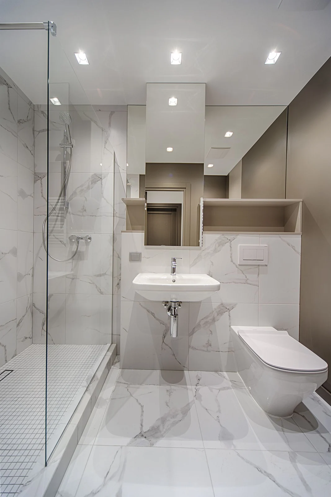 Interior of stylish light bathroom with white sink and toilet and built in shower cabin