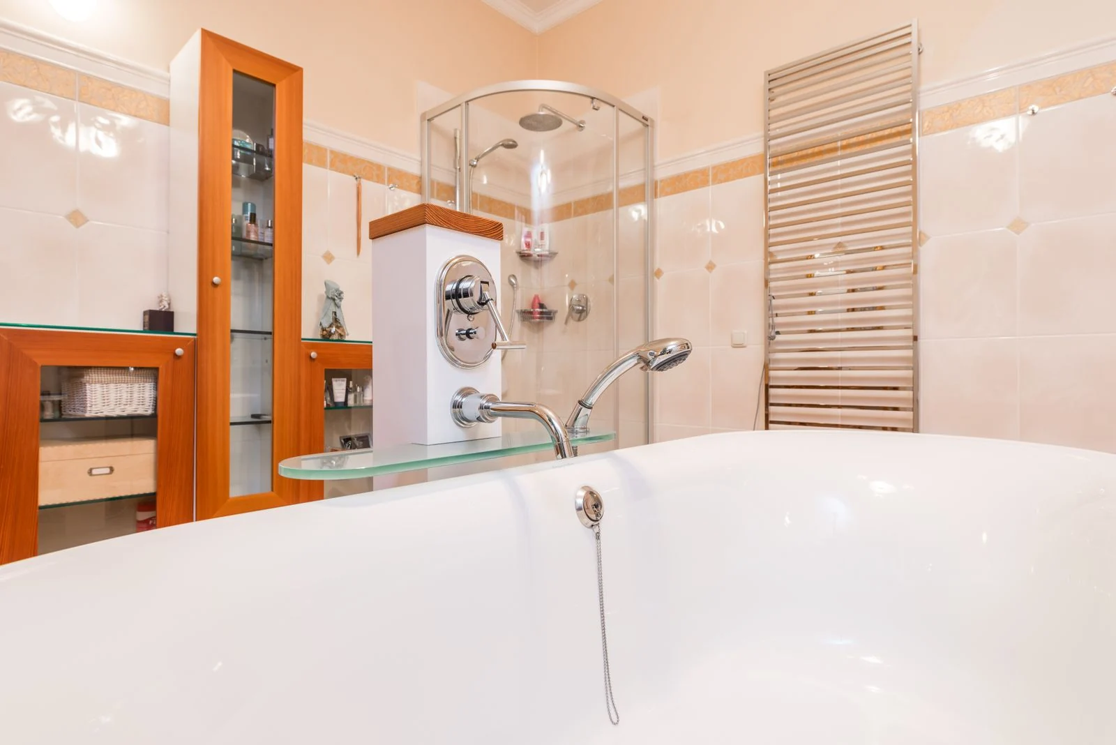 Fitted bath beside a shower enclosure