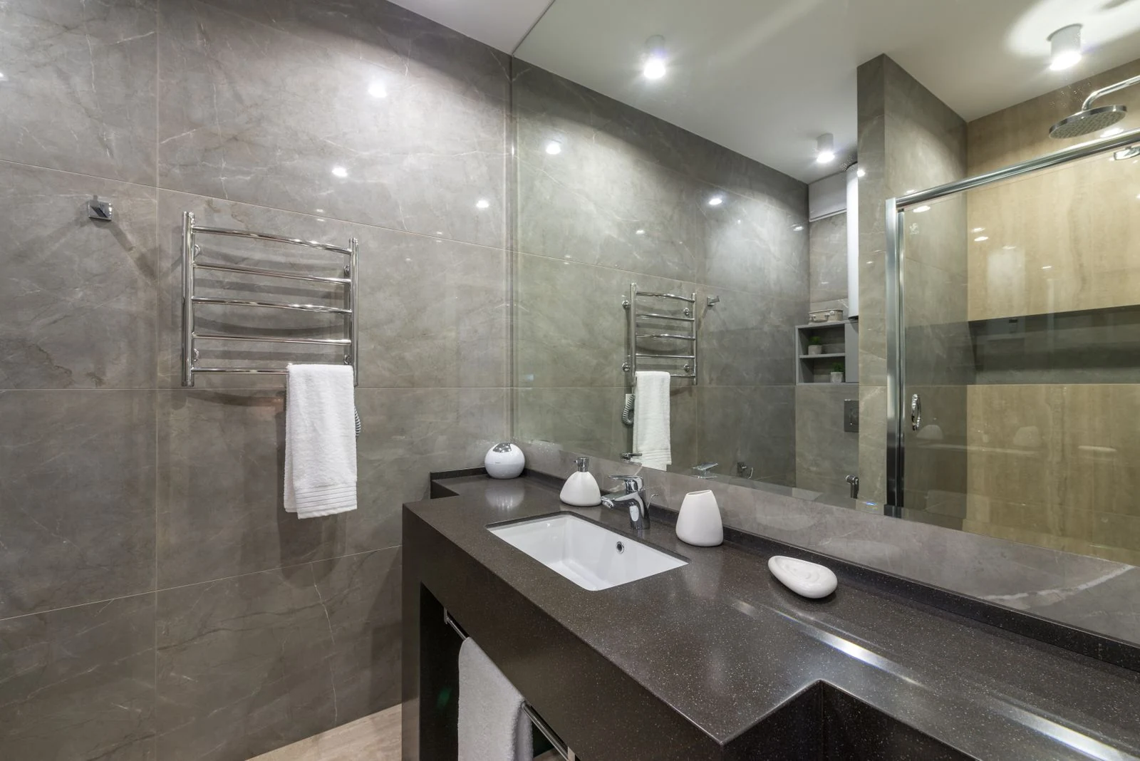 Spacious modern bathroom featuring granite countertop, glass shower, and stainless steel fixtures