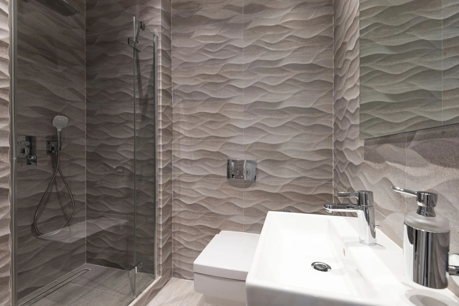 Contemporary bathroom featuring wave-patterned tiles, glass shower, and modern fixtures
